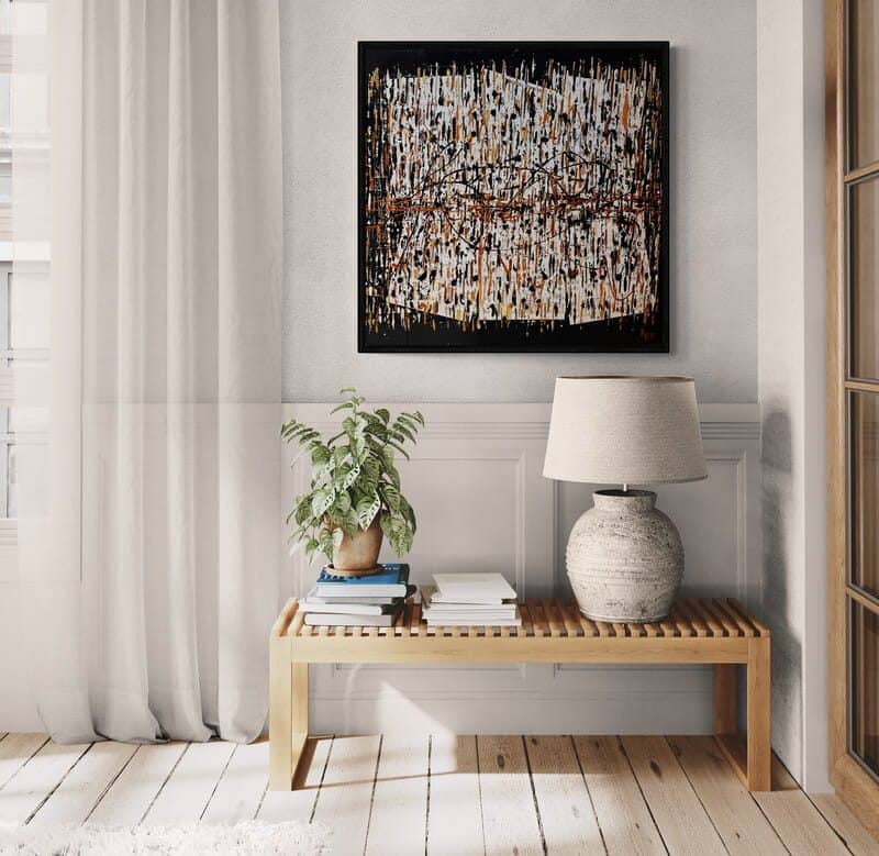 Aro Au coeur de tout painting displayed on a pale grey panelled wall above a light oak bench
