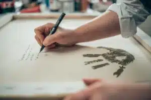 Artist Caroline Bergeron, known as ARO, inscribing a unique story onto a canvas from her new Inspire collection.
